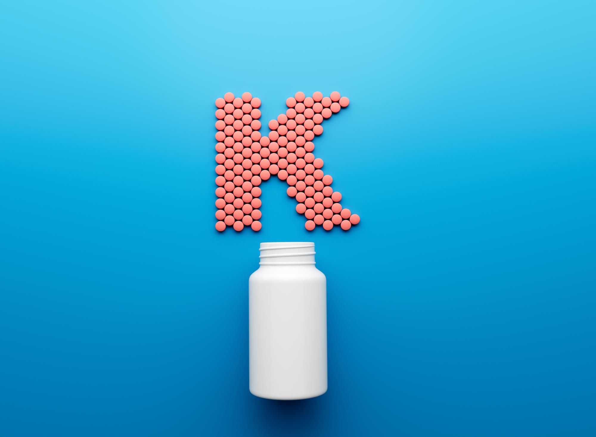 3d empty white pill bottle with k text made rounded vitamin k tablets 3d illustration 5b5ddeba