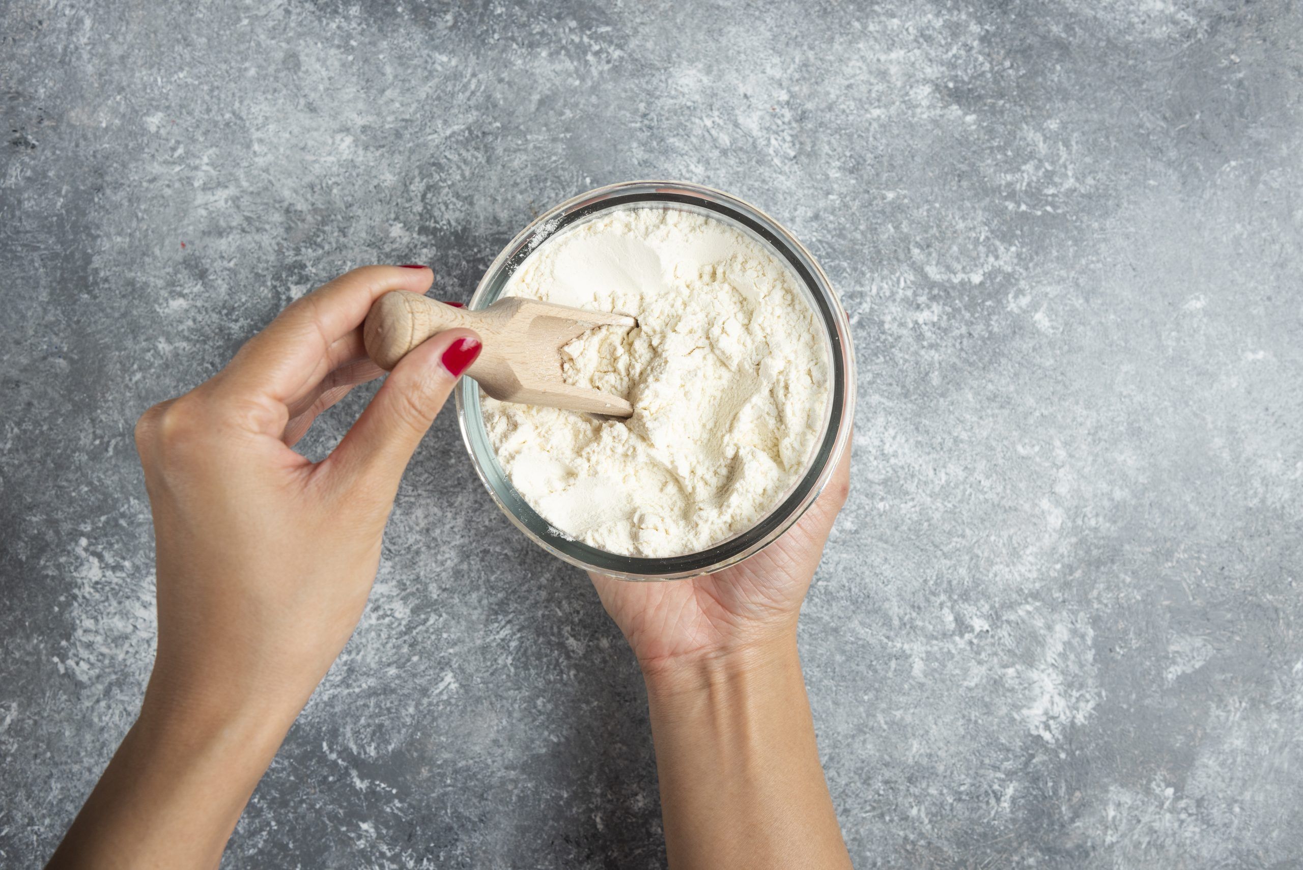woman hand holding spoon inside flour bowl scaled df9b424d