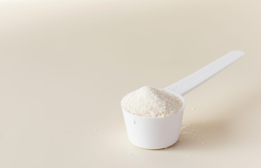 scoop with hydrolyzed collagen powder beige background concept food additives healthy copy space